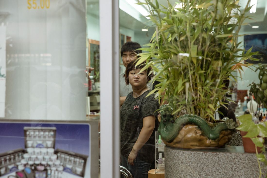 Nail salon workers watch the protesters.<br>